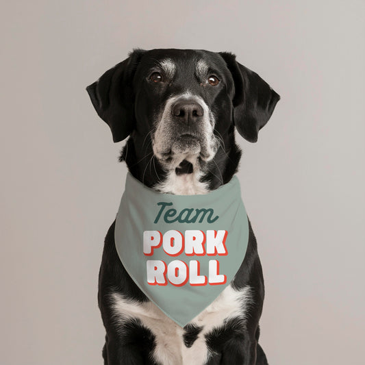 Dog wearing a bandana with 'Team Pork Roll' text